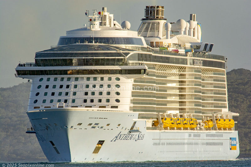 Royal Caribbean's 347m ANTHEM OF THE SEAS (2015/IMO 9656101/168666gt/4905 passenger at maximum capacity) arrives into Auckland in the yellow light of sunrise, hard on the heels of Disney Cruise Line's DISNEY WONDER which is part through her final cruise season downunder. 7 December 2025. Photo by Â© 2025 SeapixOnline.com